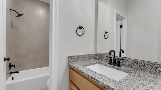 a bathroom with a granite countertop sink and a mirror