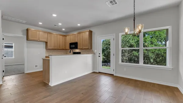 a kitchen with granite countertop a sink stove and microwave