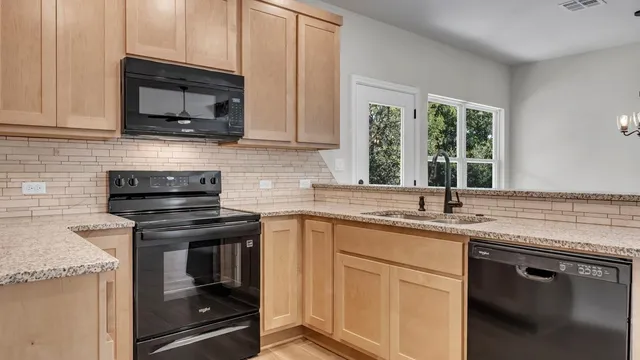 a kitchen with stainless steel appliances granite countertop a sink stove and microwave