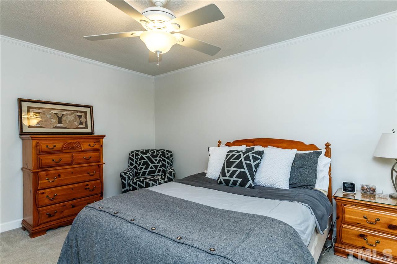 4500 Rutland Court Raleigh, NC 27613 - Photo 15 of 23 a bedroom with a bed and a chandelier