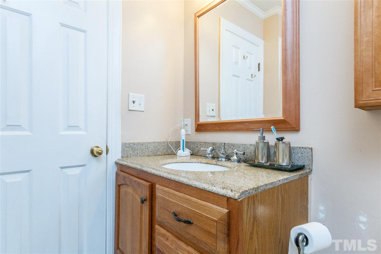 4500 Rutland Court Raleigh, NC 27613 - Photo 17 of 23 a bathroom with a granite countertop sink and a mirror