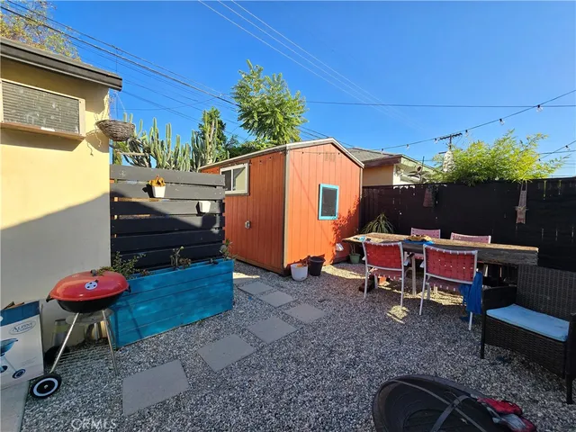 a view of a backyard with table and chairs potted plants and a couch