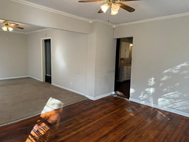 a view of a livingroom with a ceiling fan and wooden floor