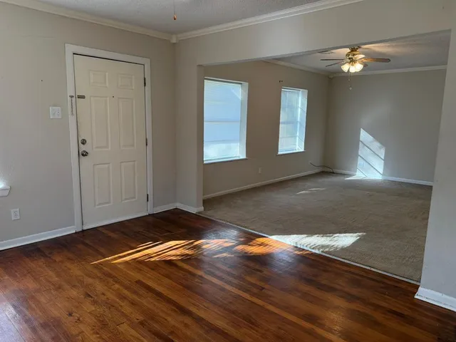 a view of empty room with window and wooden floor