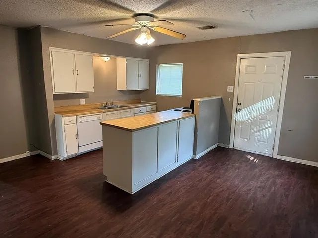 an open kitchen with wooden floor and window