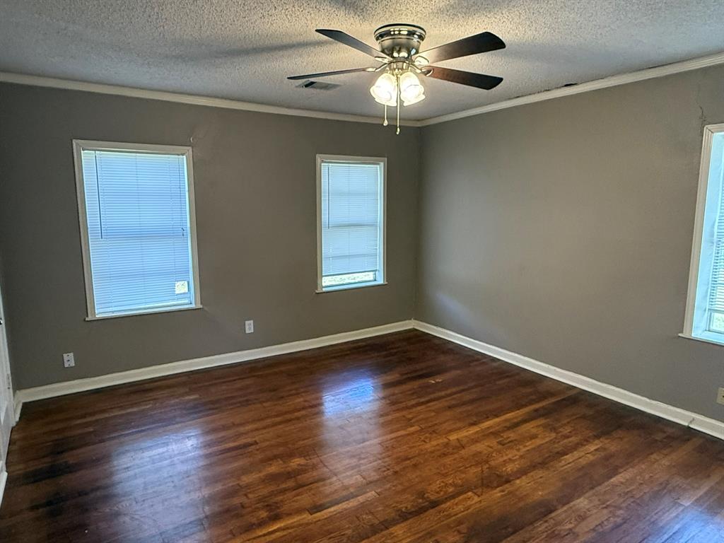 4216 Knoll Drive Waco, TX 76708 - Photo 8 of 12 a view of an empty room with wooden floor and a window