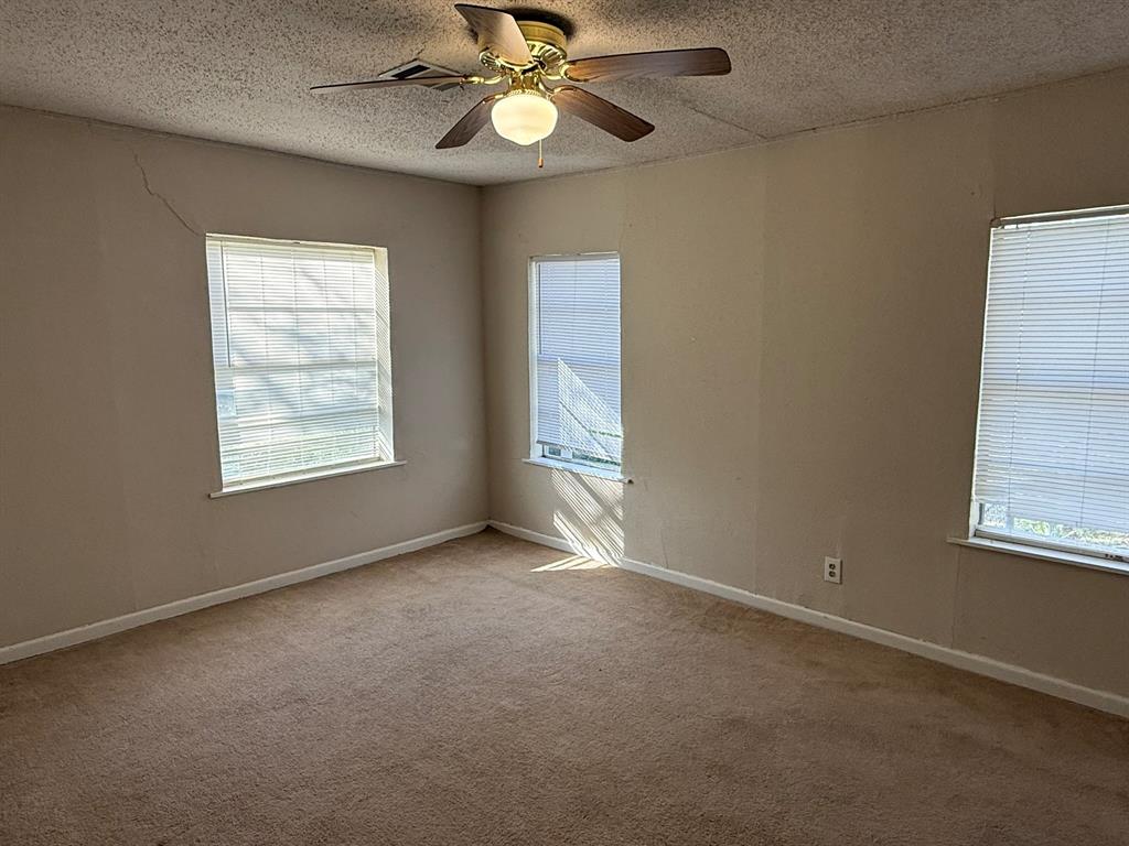 4216 Knoll Drive Waco, TX 76708 - Photo 10 of 12 an empty room with windows and fan