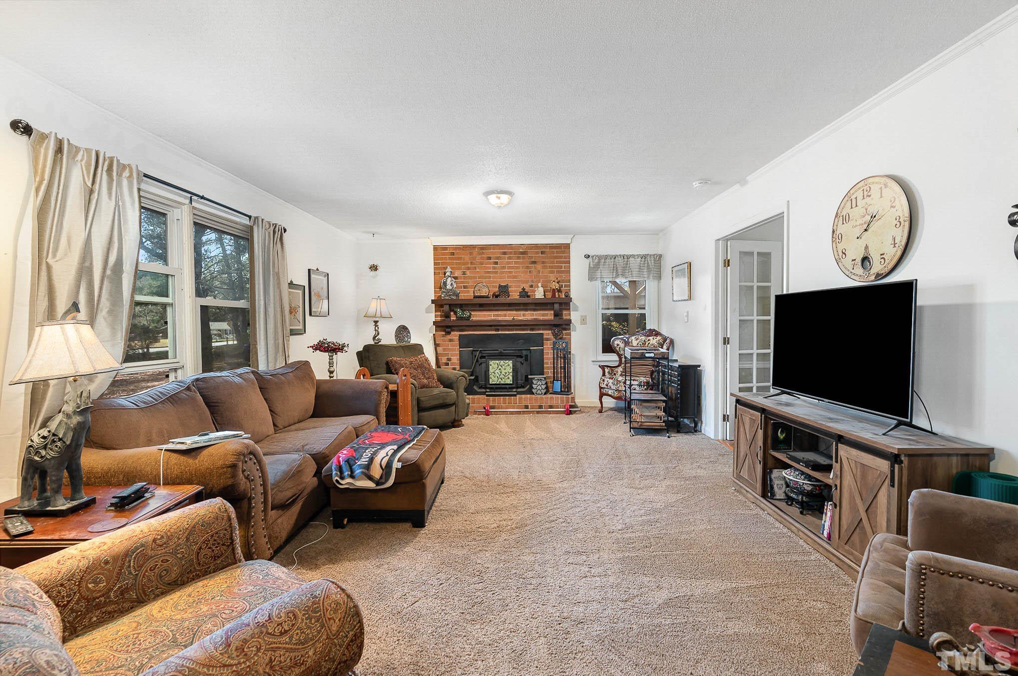 1613 Sanders Road Stem, NC 27581 - Photo 5 of 19 a living room with furniture and a flat screen tv