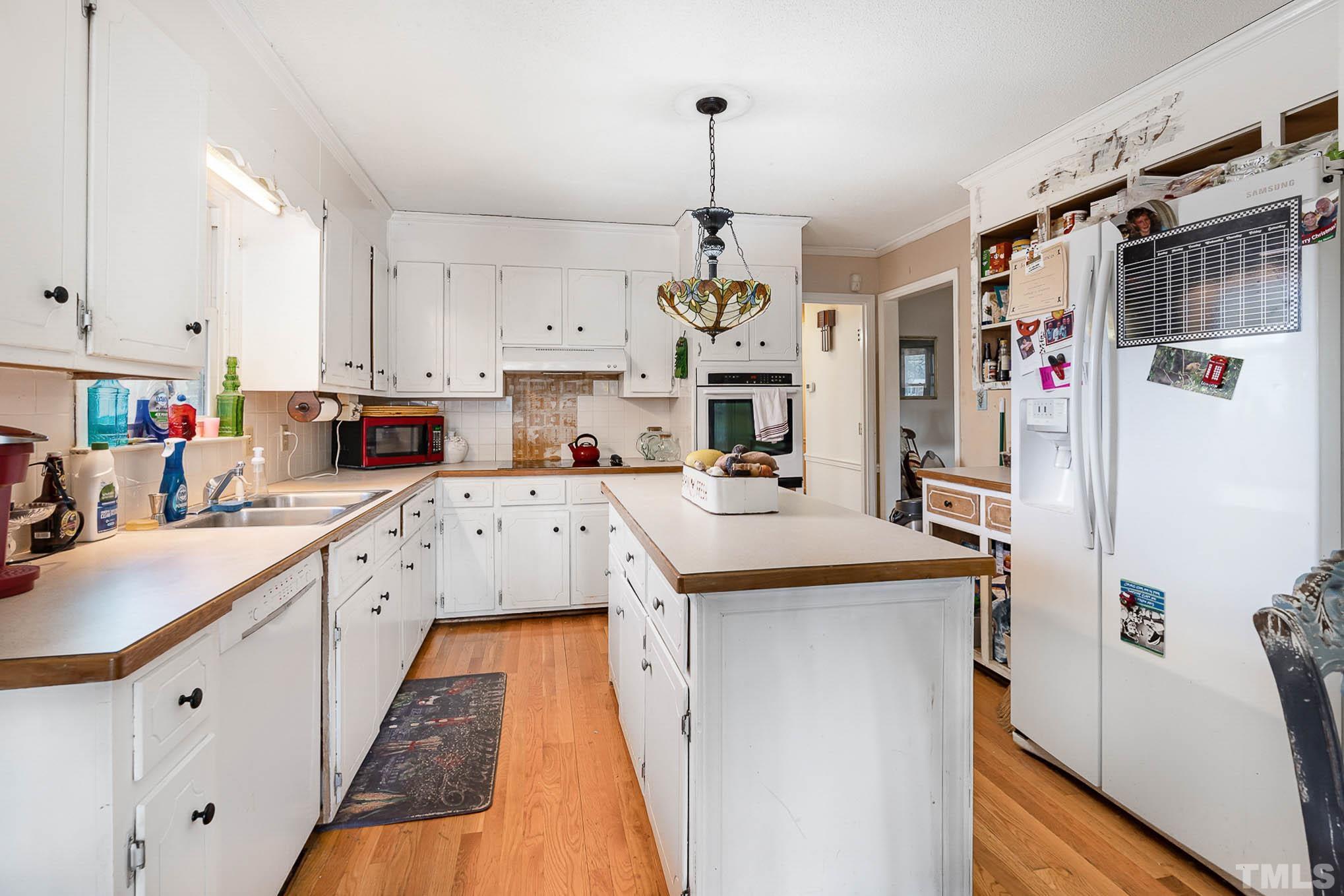 1613 Sanders Road Stem, NC 27581 - Photo 10 of 19 a kitchen with stainless steel appliances kitchen island granite countertop a refrigerator and a sink