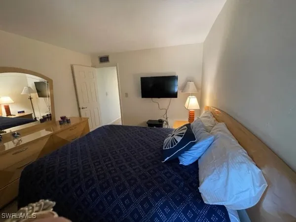 a bedroom with a bed and a flat screen tv