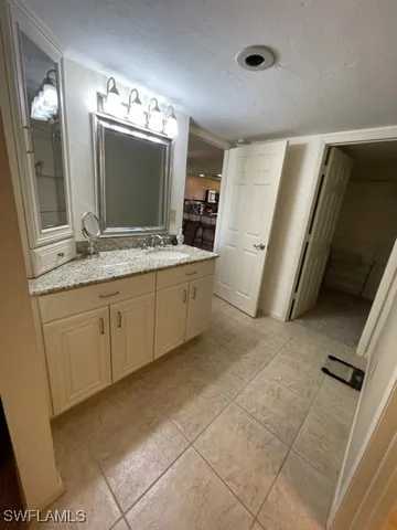 a bathroom with a granite countertop sink a mirror and a vanity