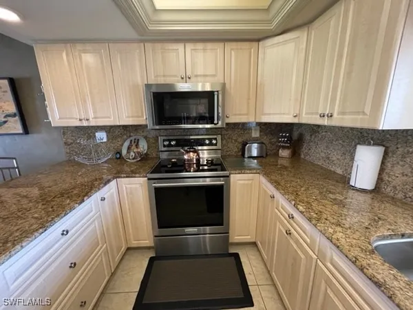 a kitchen with granite countertop a sink a stove and a microwave