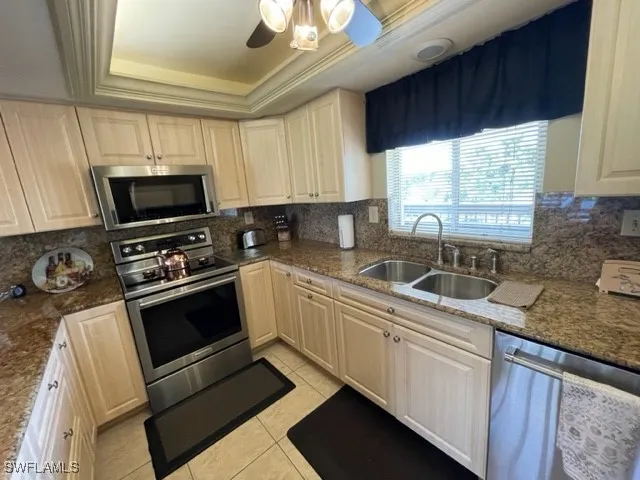 a kitchen with stainless steel appliances a stove sink microwave and window