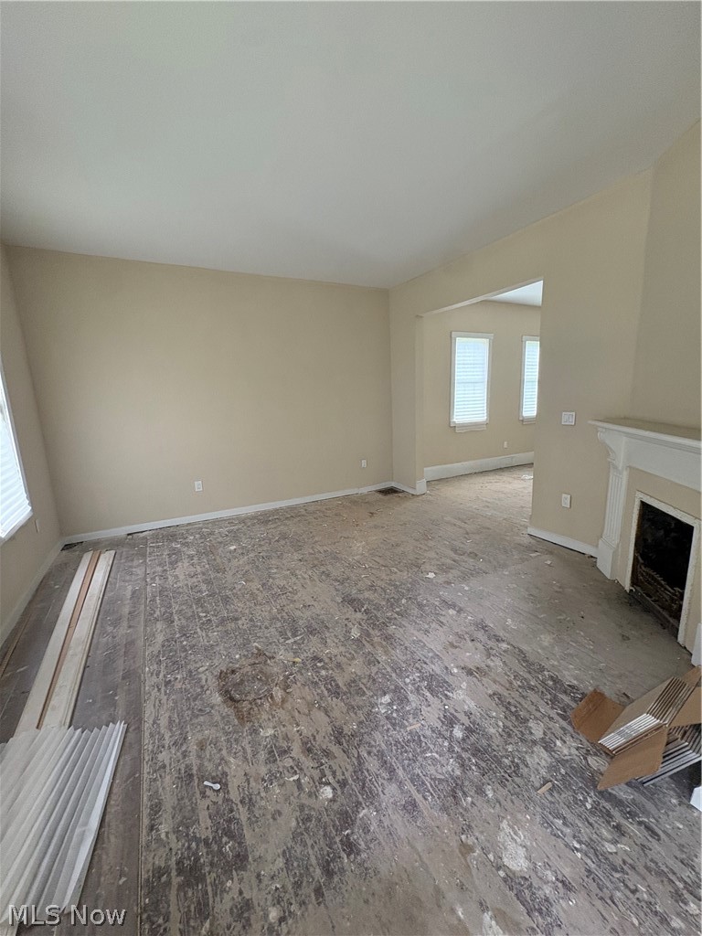 1210 Lawrence Road Northeast Canton, OH 44705 - Photo 11 of 38 Neutral wall tones, multiple windows with blinds, open doorway, and a white mantelpiece