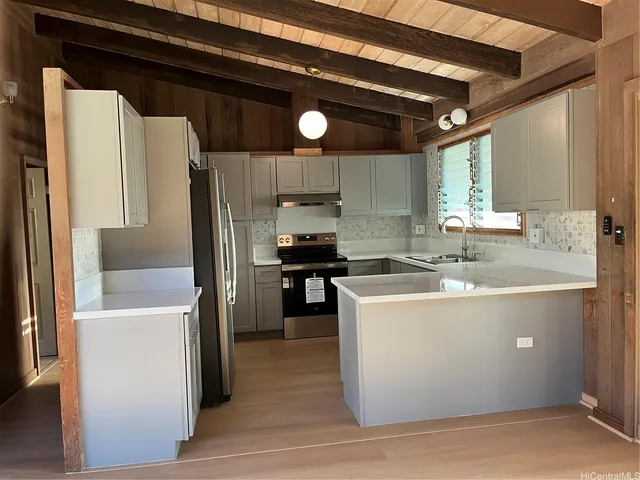 a kitchen with stainless steel appliances granite countertop a sink a stove and a refrigerator