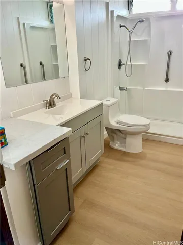 a bathroom with a sink a toilet and shower