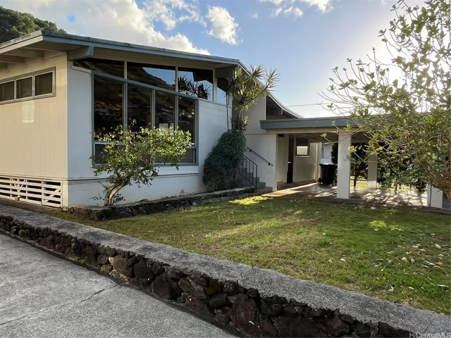 a view of a house with a yard and potted plants