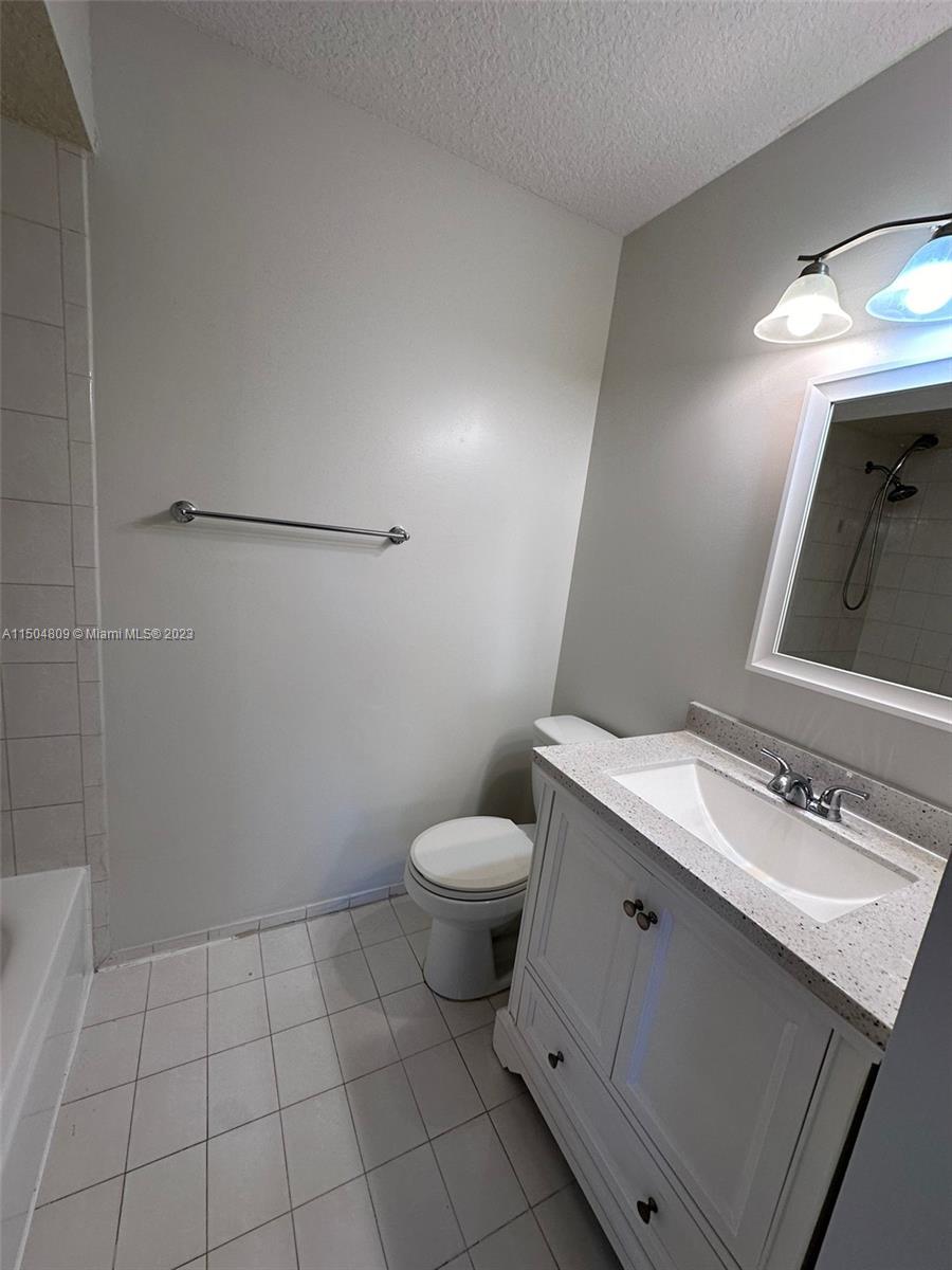 8260 Northwest 10th Street, Unit 7 Miami, FL 33126 - Photo 15 of 23 a bathroom with a sink a toilet and mirror