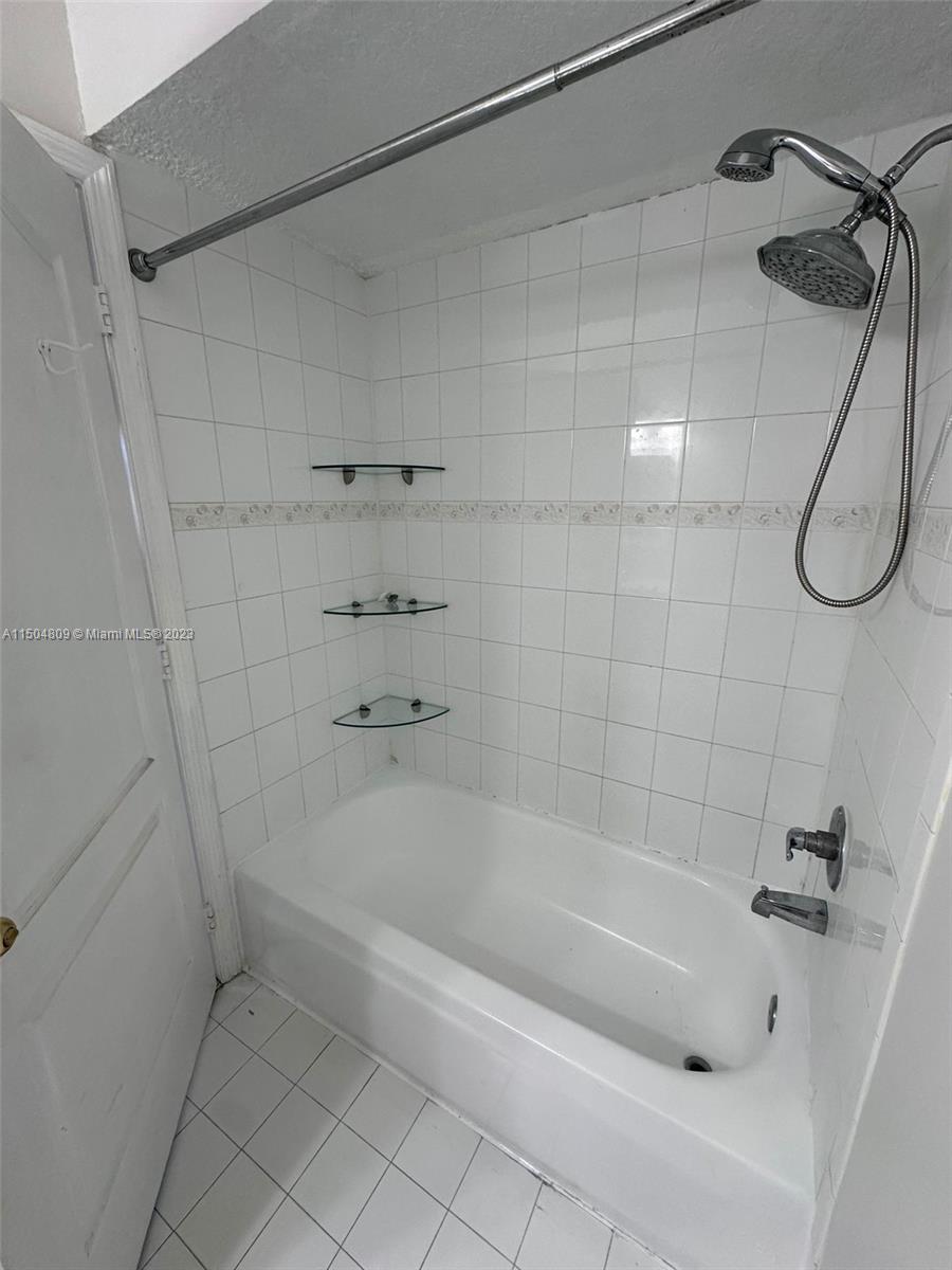 8260 Northwest 10th Street, Unit 7 Miami, FL 33126 - Photo 17 of 23 a bathroom with a bath tub with a shower