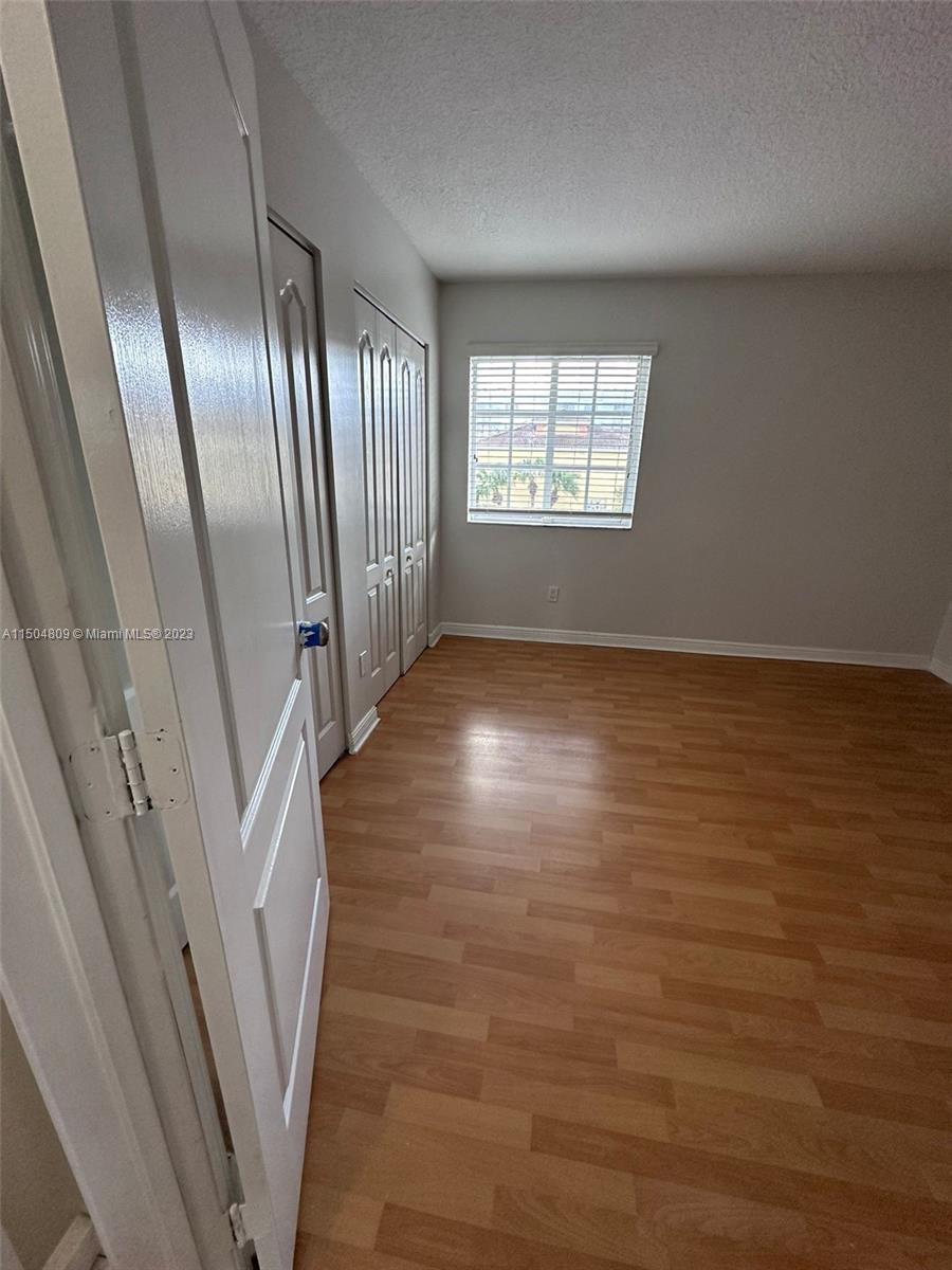 8260 Northwest 10th Street, Unit 7 Miami, FL 33126 - Photo 18 of 23 an empty room with wooden floor and windows