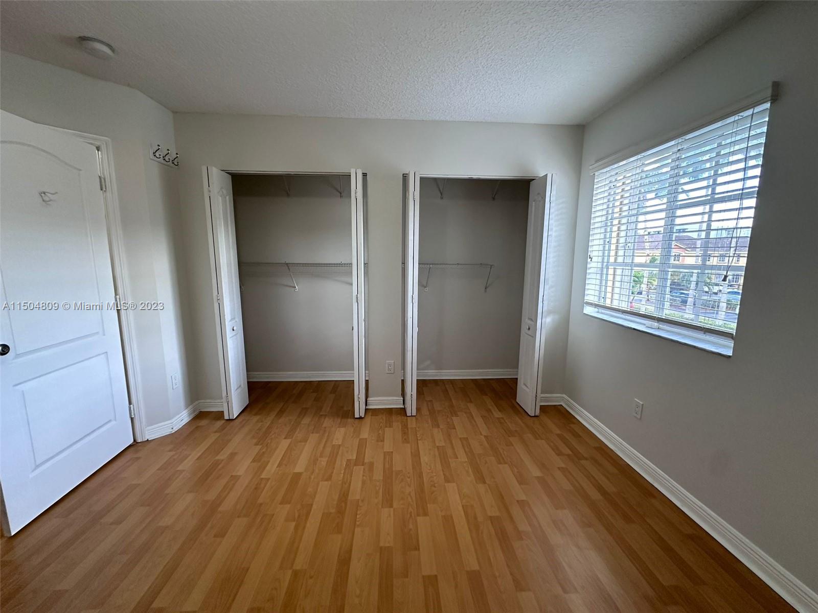 8260 Northwest 10th Street, Unit 7 Miami, FL 33126 - Photo 20 of 23 an empty room with wooden floor closet and windows