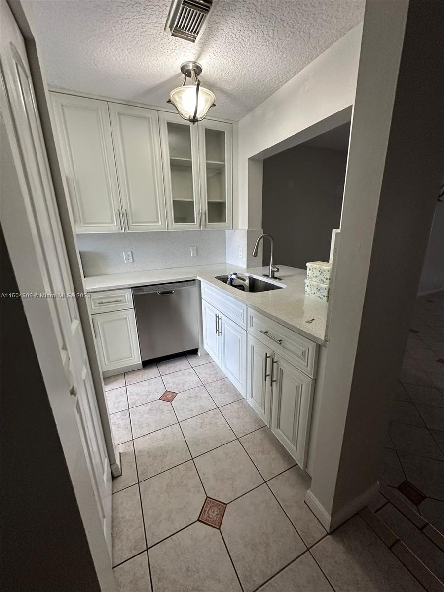 8260 Northwest 10th Street, Unit 7 Miami, FL 33126 - Photo 4 of 23 a kitchen with stainless steel appliances a stove a sink and a refrigerator