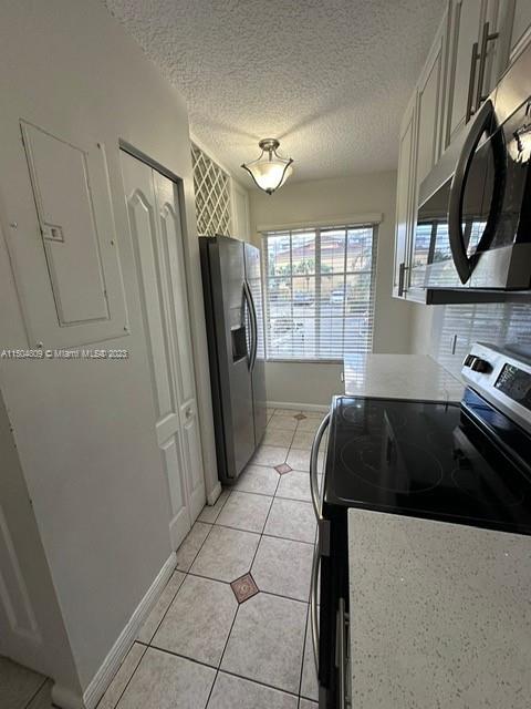 8260 Northwest 10th Street, Unit 7 Miami, FL 33126 - Photo 5 of 23 a kitchen with a refrigerator a stove a sink and a window
