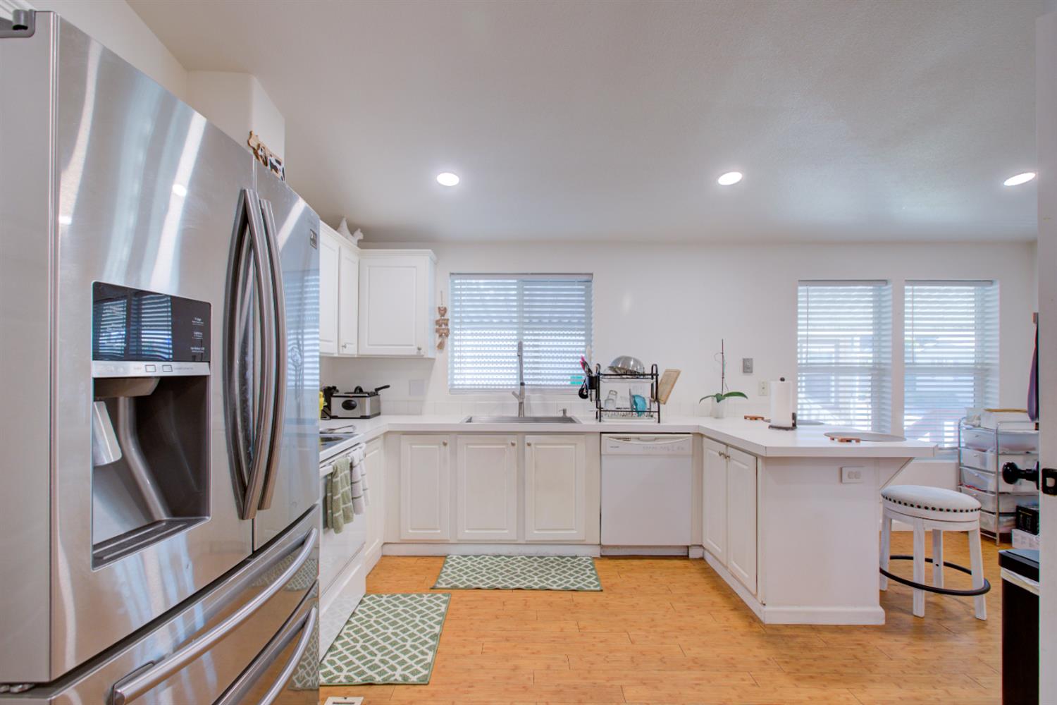 6450 North Winton Way, Unit 76 Winton, CA 95301 - Photo 2 of 36 a kitchen with stainless steel appliances a sink a stove a refrigerator cabinets and a window