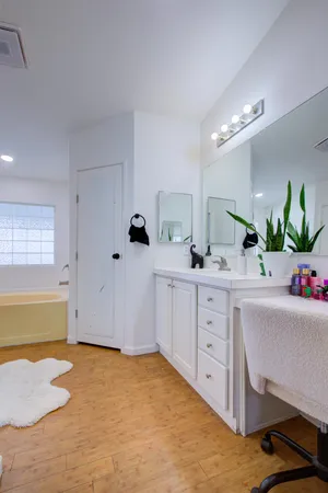a spacious bathroom with a granite countertop sink a mirror and a bathtub