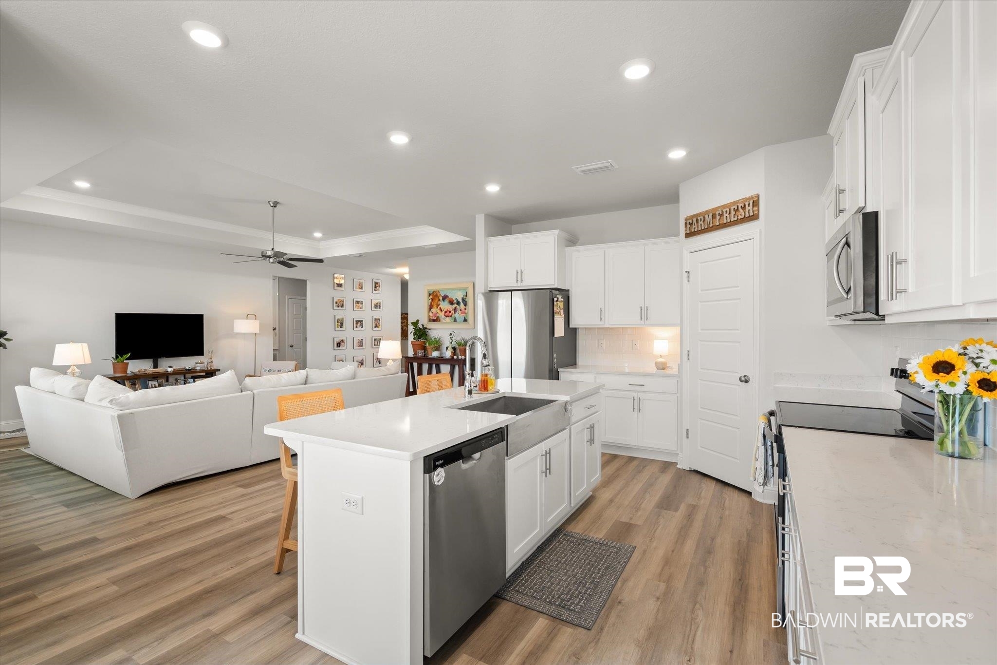 1167 Provision Road Mobile, AL 36608 - Photo 7 of 20 Kitchen with light wood-style flooring, appliances with stainless steel finishes, white cabinets, and a tray ceiling