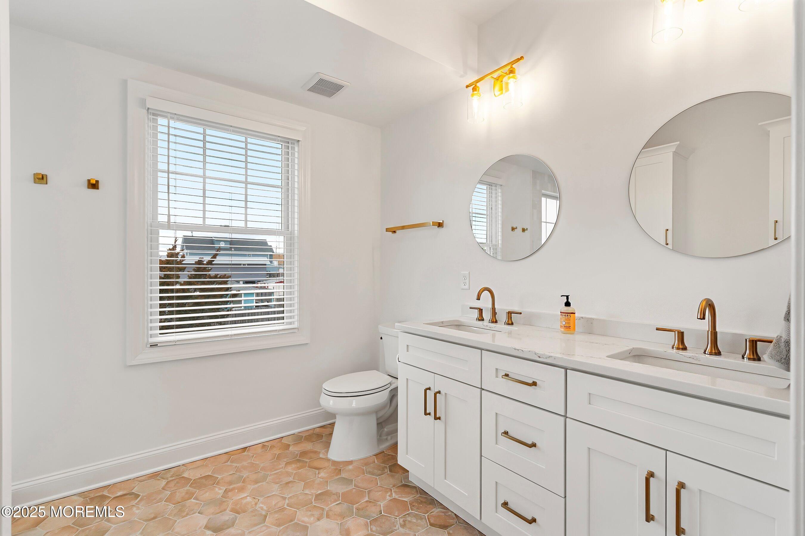 543 Brielle Road Manasquan, NJ 08736 - Photo 16 of 36 a bathroom with a toilet a sink and a mirror