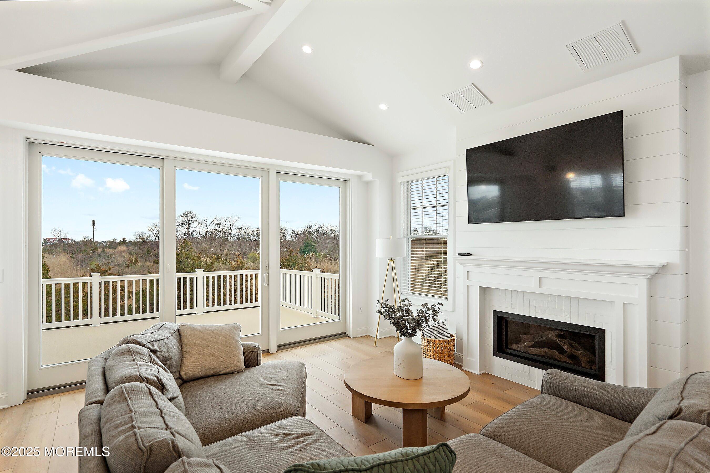 543 Brielle Road Manasquan, NJ 08736 - Photo 24 of 36 a living room with furniture a fireplace and a flat screen tv