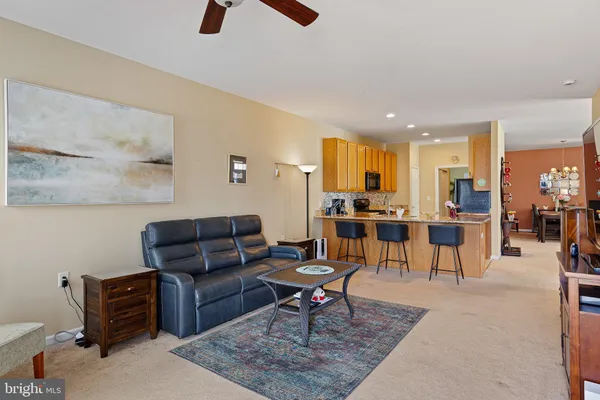 a living room with furniture a rug and kitchen view