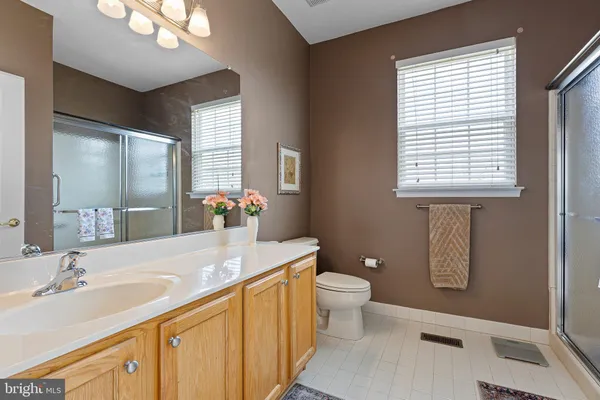 a bathroom with a granite countertop sink and a large mirror