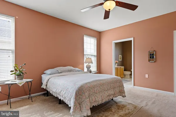 a bedroom with a bed chandelier and a window