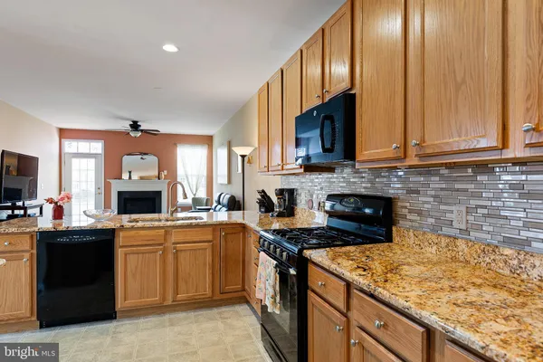 a kitchen with granite countertop a sink stove and cabinets