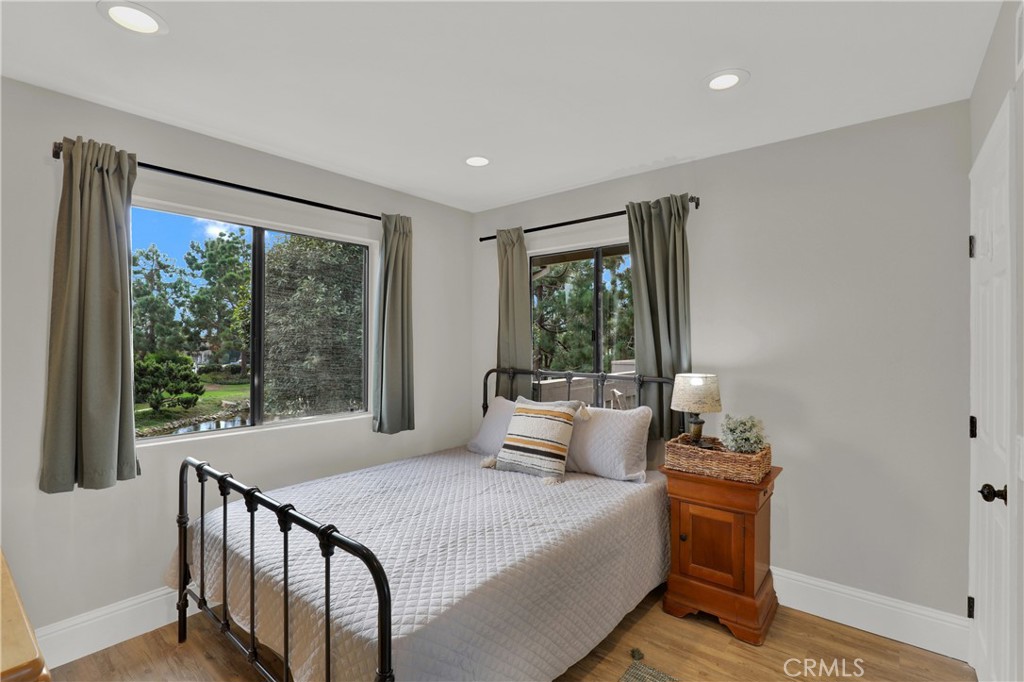 27112 Mill Pond Road, Unit 2 Dana Point, CA 92624 - Photo 27 of 50 a bedroom with a bed and wooden floor