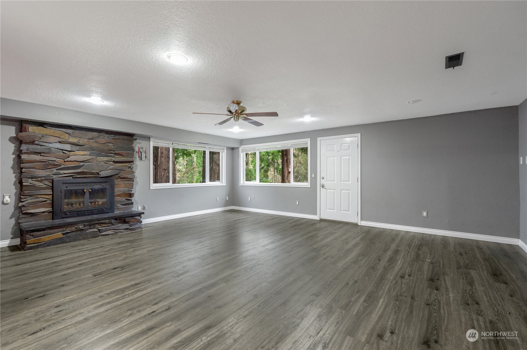 2712 Seminary Hill Road Centralia, WA 98531 - Photo 26 of 40 an empty room with wooden floor fireplace and windows