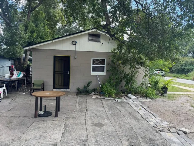 a backyard of a house with table and chairs