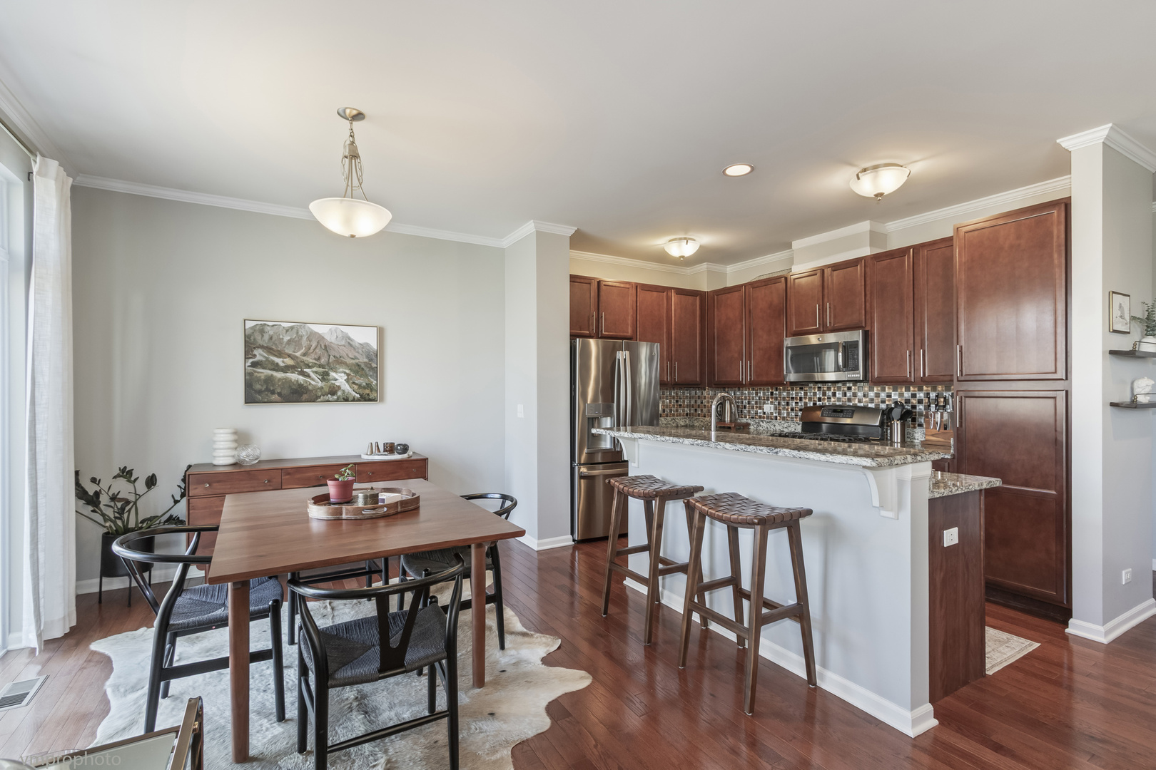 28 East Moseley Road Palatine, IL 60074 - Photo 5 of 25 a kitchen with stainless steel appliances kitchen island granite countertop a dining table chairs refrigerator sink and cabinets