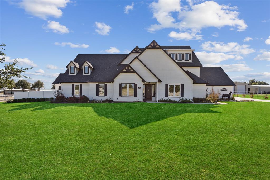 a view of a big house with a big yard and large trees