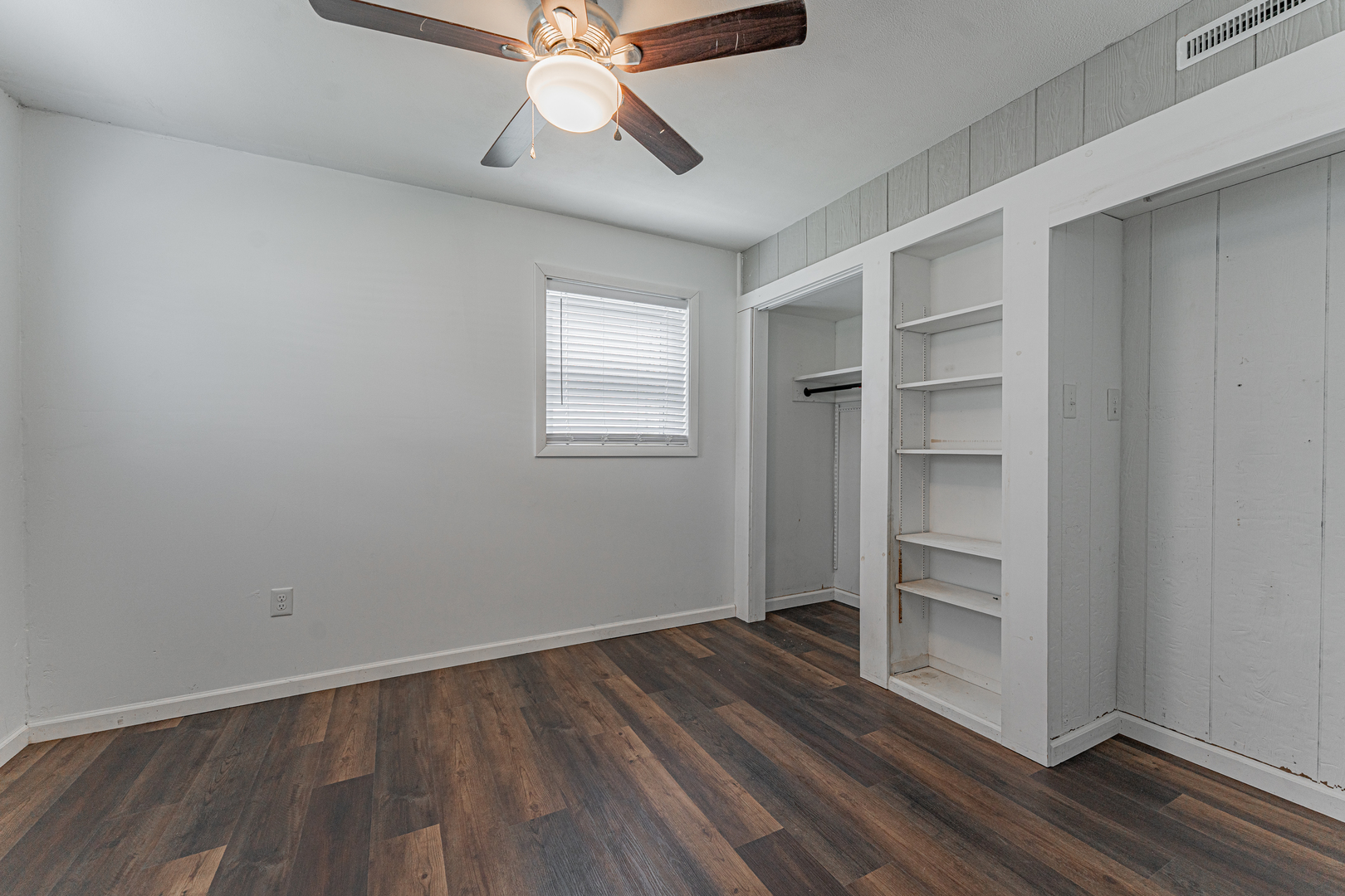 805 South Grove Street Normal, IL 61761 - Photo 5 of 32 an empty room with wooden floor closet chandelier fan and windows