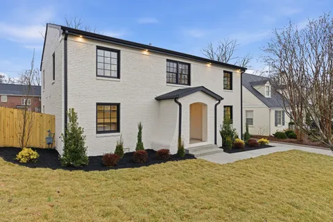 a view of a white house with a yard