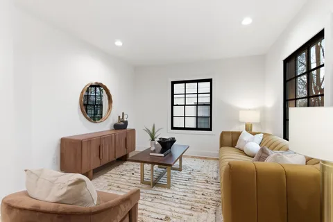 a living room with furniture a rug and a window
