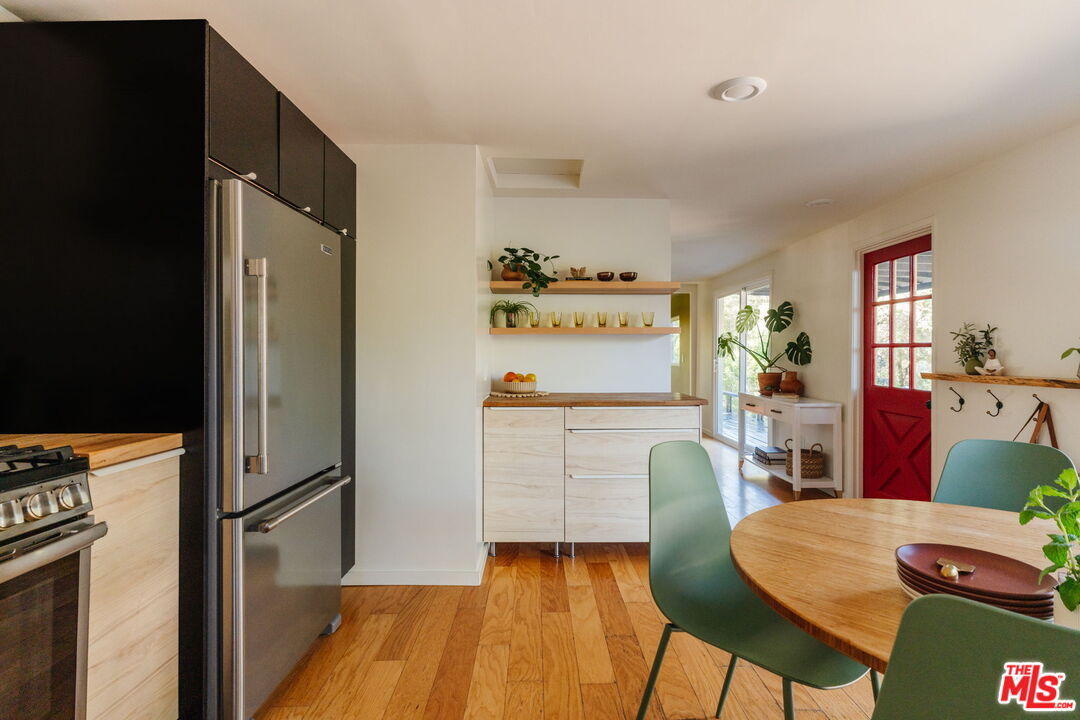 20906 Fontaine Road Topanga, CA 90290 - Photo 5 of 73 a kitchen with stainless steel appliances granite countertop a refrigerator a stove a dining table and chairs with wooden floor
