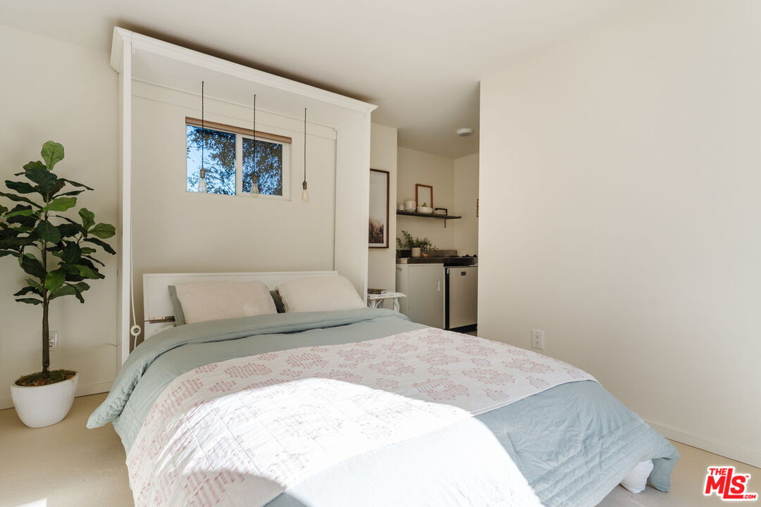 20906 Fontaine Road Topanga, CA 90290 - Photo 53 of 73 a bedroom with a large bed and a potted plant