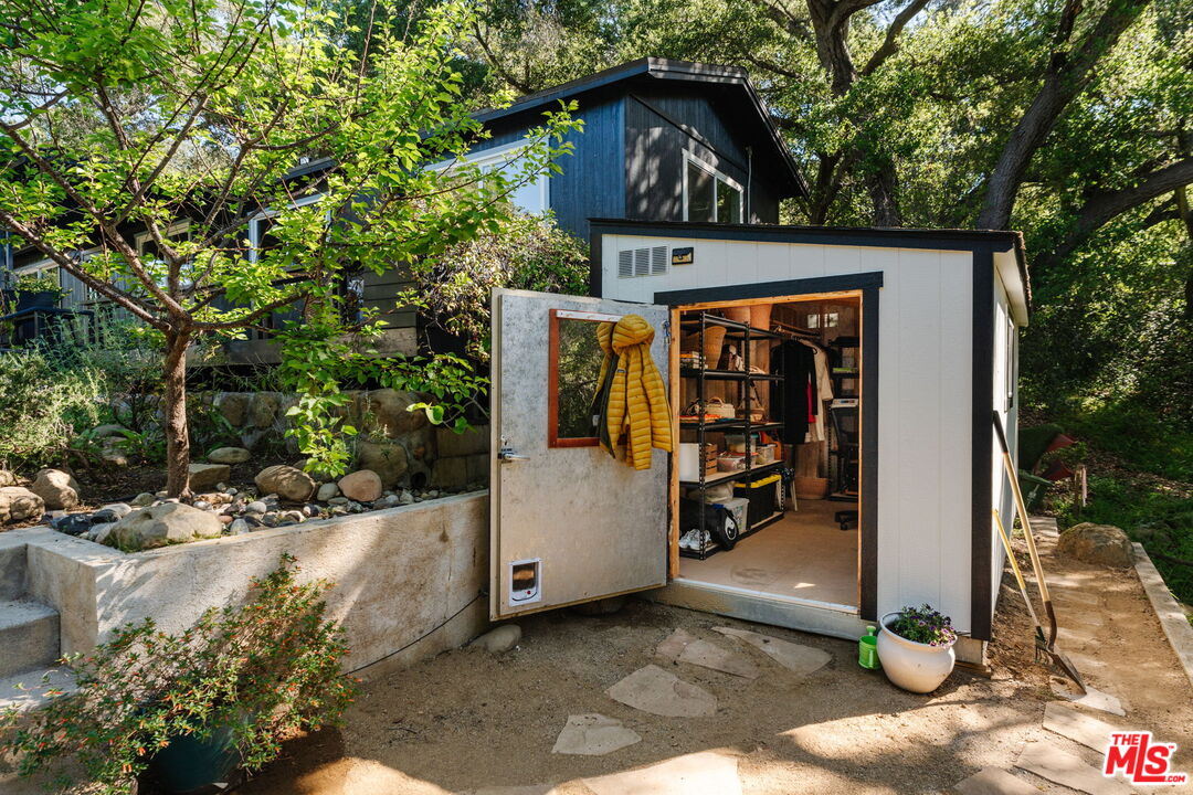 20906 Fontaine Road Topanga, CA 90290 - Photo 59 of 73 a view of a wooden house with a large window and potted plants