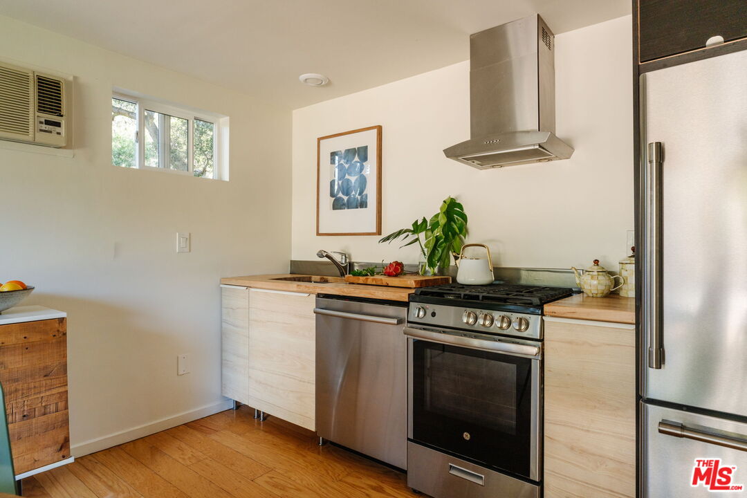 20906 Fontaine Road Topanga, CA 90290 - Photo 6 of 73 a kitchen with stainless steel appliances a stove a refrigerator and a window