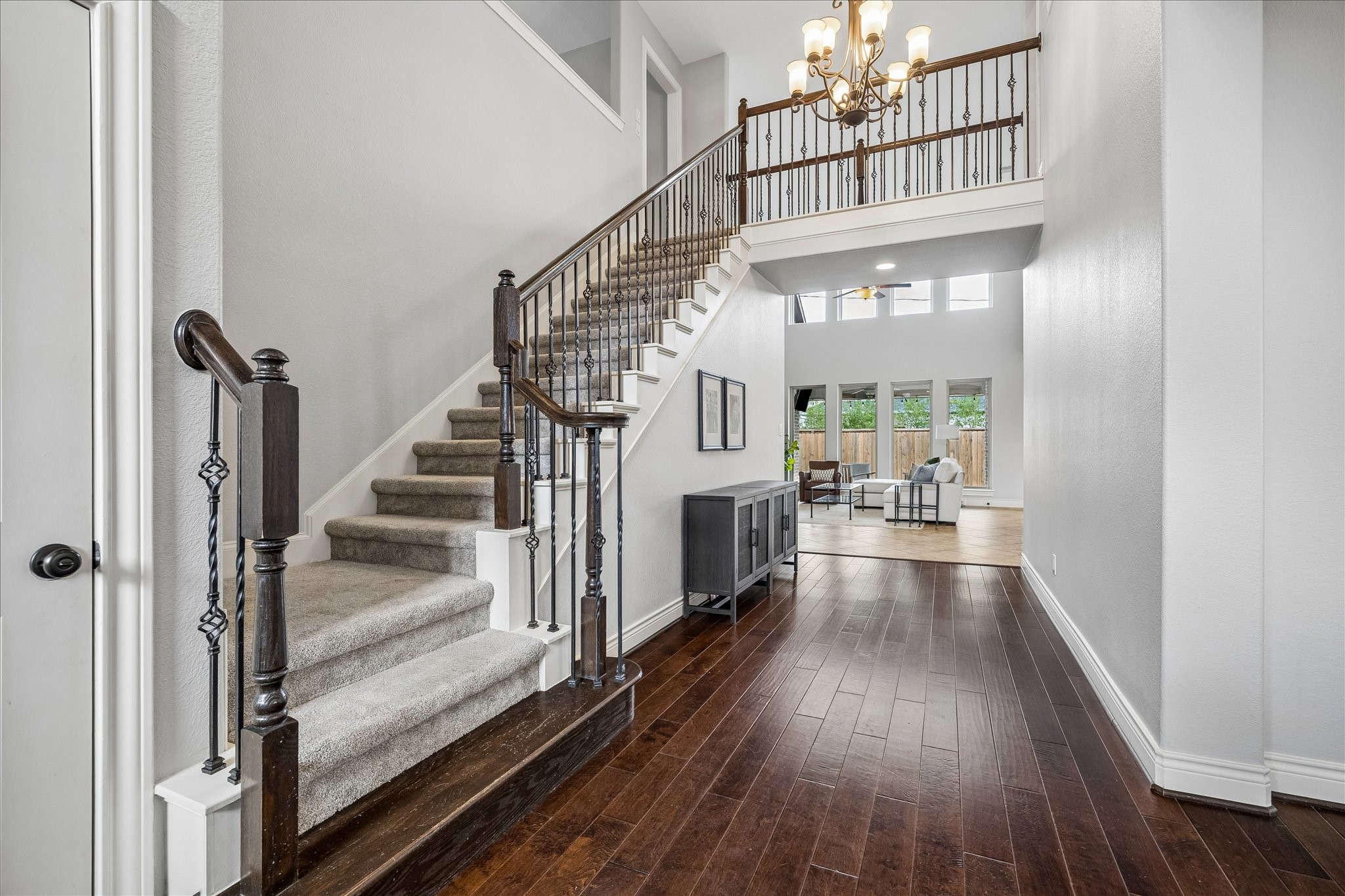 1616 Hewitt Drive Houston, TX 77018 - Photo 3 of 44 Two story foyer makes a stunning first impression with rich hardwood flooring and a sweeping staircase featuring stained wood handrails and iron balusters. An open second floor landing above adds architectural interest and natural light.