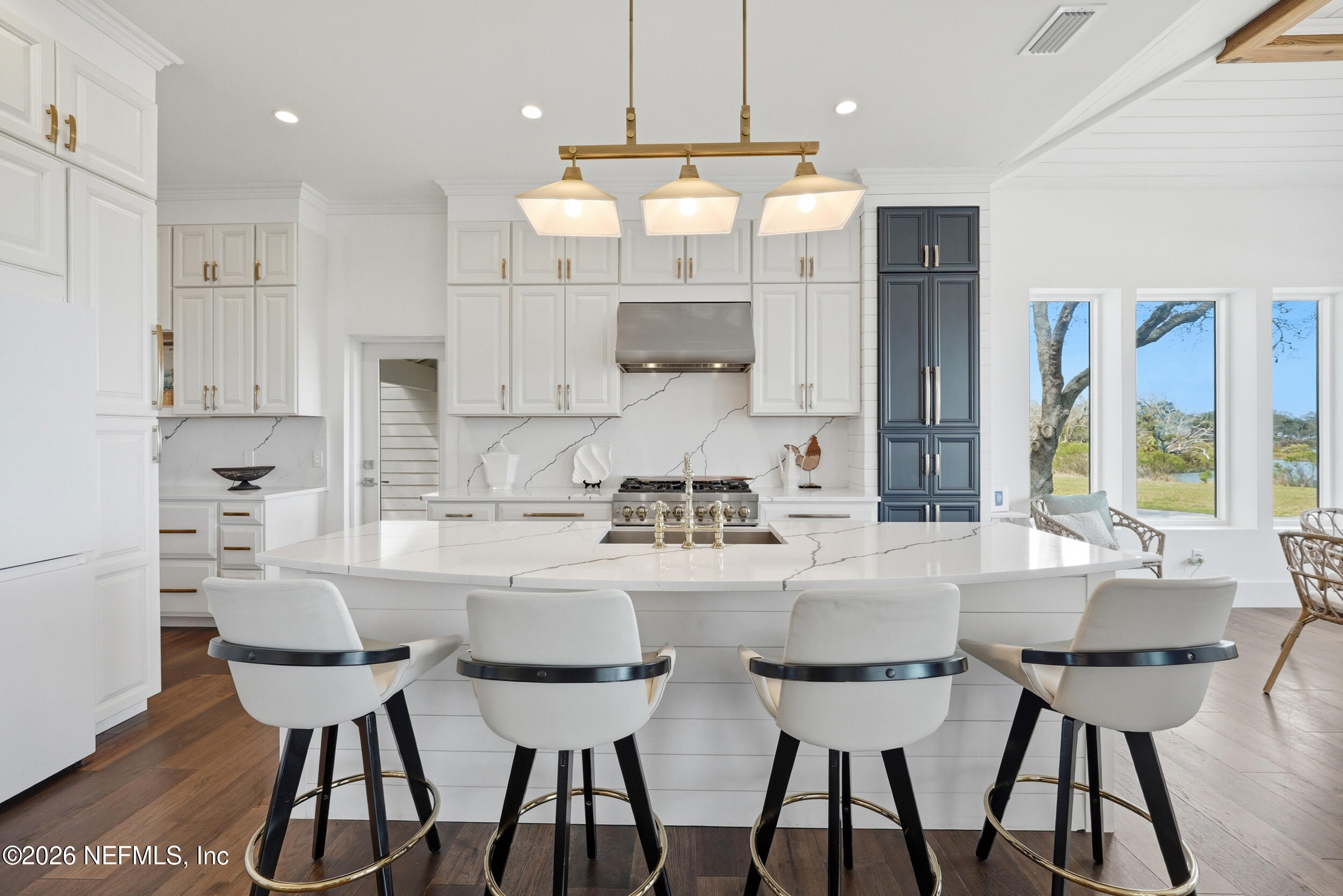 2406 Shore Drive St. Augustine, FL 32086 - Photo 18 of 108 a kitchen with kitchen island a dining table chairs and white cabinets